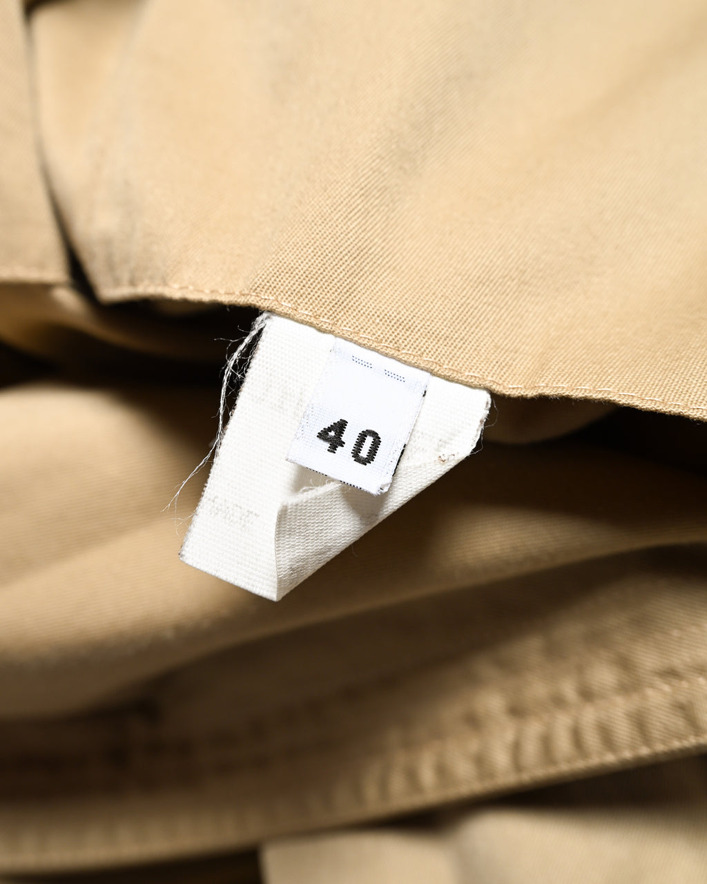ベージュのコットンファブリックの内側に配された、サイズ「40」表記の内タグを写したカット。
