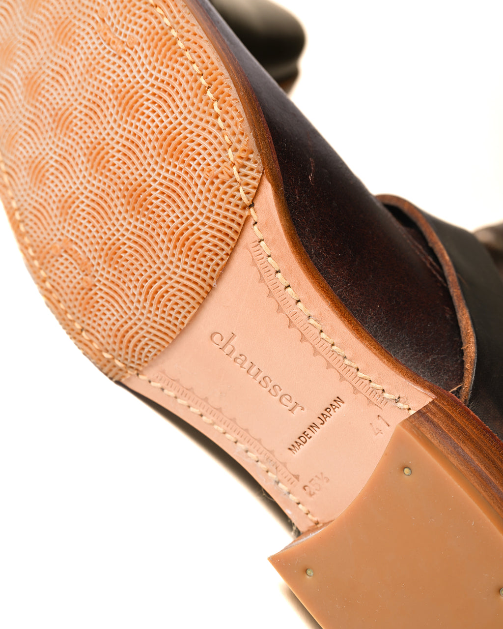 ソール底面に刻まれたchausserのブランド刻印と「MADE IN JAPAN」表記を捉えたカット。レザーソールに配されたハーフラバーソールの凹凸も確認できます。