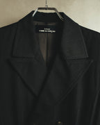 端正なノッチドラペルと、襟元に配された「tricot COMME des GARÇONS」ネームタグを捉えたディテールカット。ブラックの毛100パーセント表地と総裏仕立ての内側が確認できます。