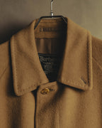 キャメルベージュの起毛感ある襟元に、旧来のBurberrysロゴと騎士図案入りのタグ、首元のボタンを収めたディテールカット。