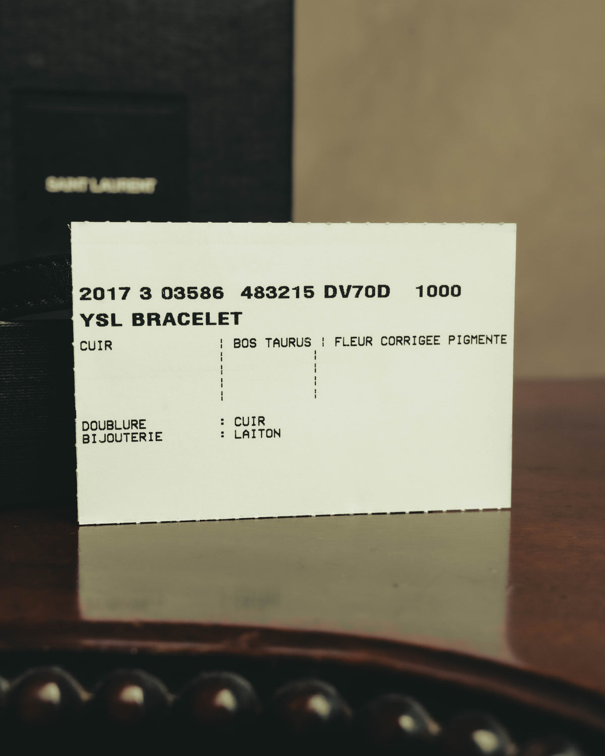 「YSL BRACELET」の表記と品番、レザーおよび真鍮の素材表示が確認できる商品タグのカット。