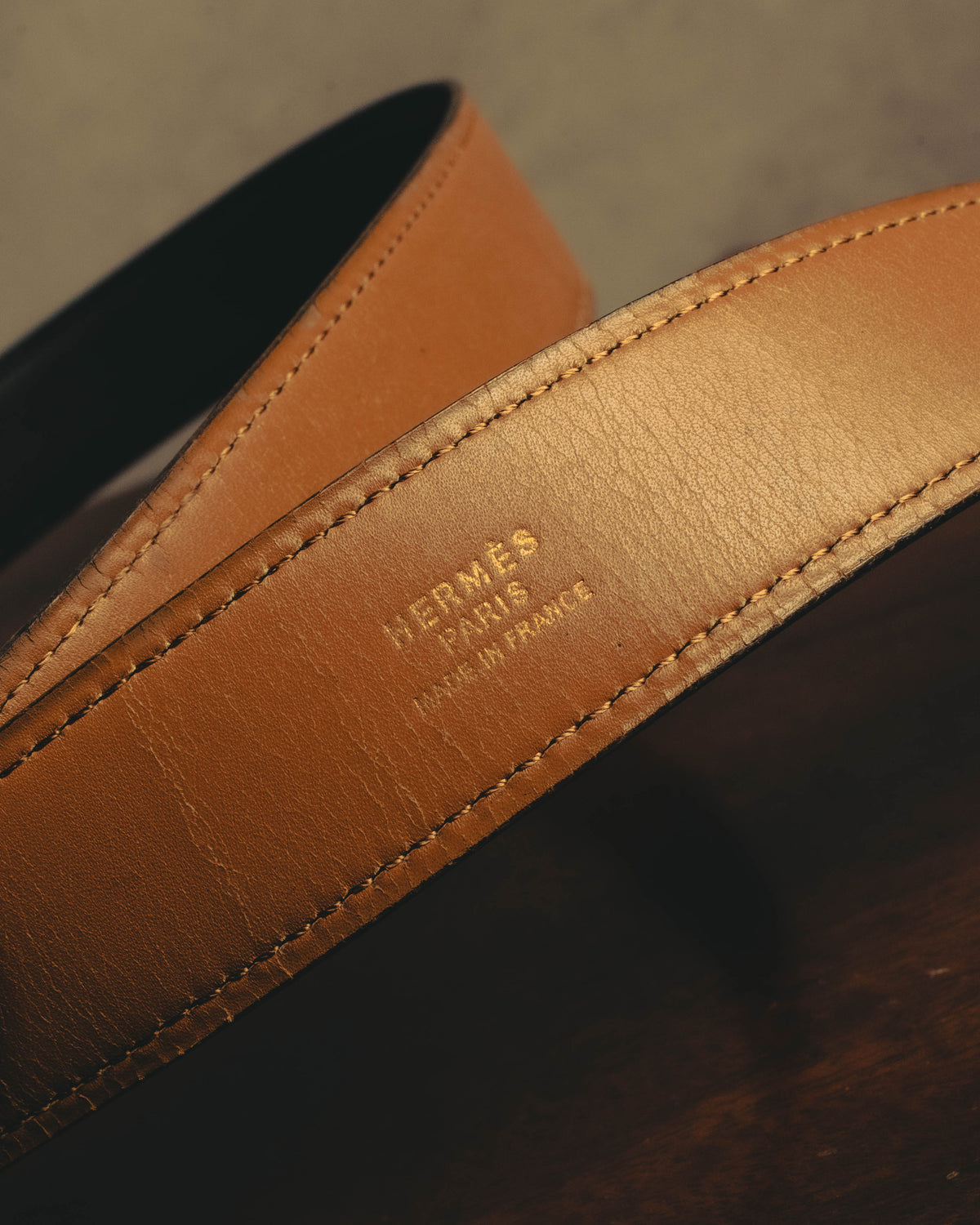 明るいキャメルブラウンのレザーを使用したベルト裏面に、HERMÈS PARISの刻印が配されたディテールカット。両端にはステッチが施されています。