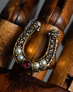 "Alexandar McQueen" Horseshoe motif red stone top ring