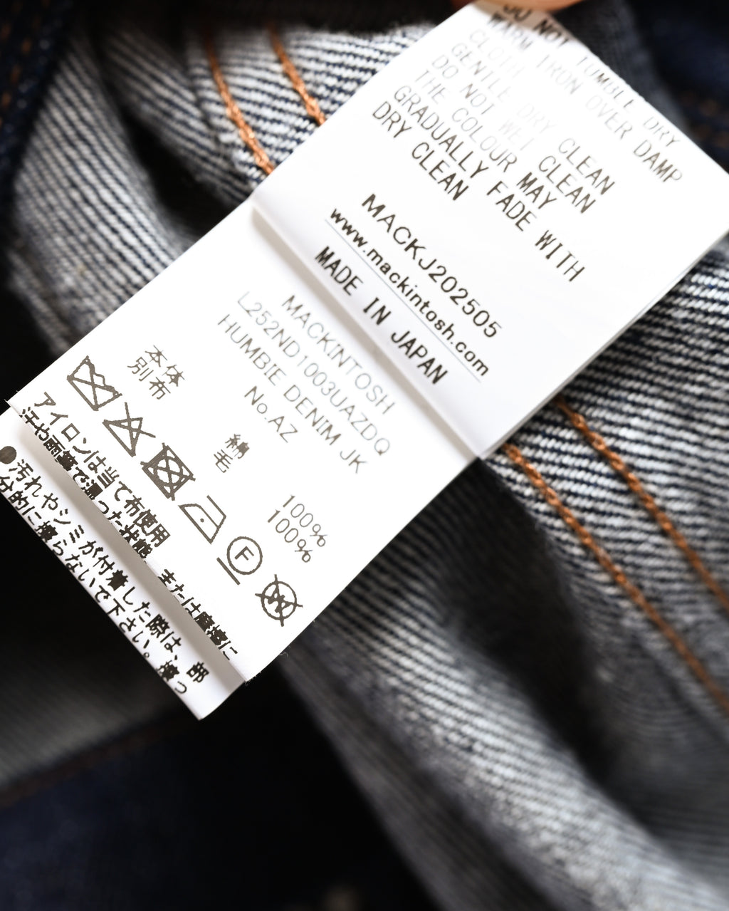 内側の品質表示タグを捉えたカット。品番 L252ND1003UAZDQ、モデル名 HUMBIE DENIM JK、綿100パーセントの本体素材と日本製表記が確認できます。
