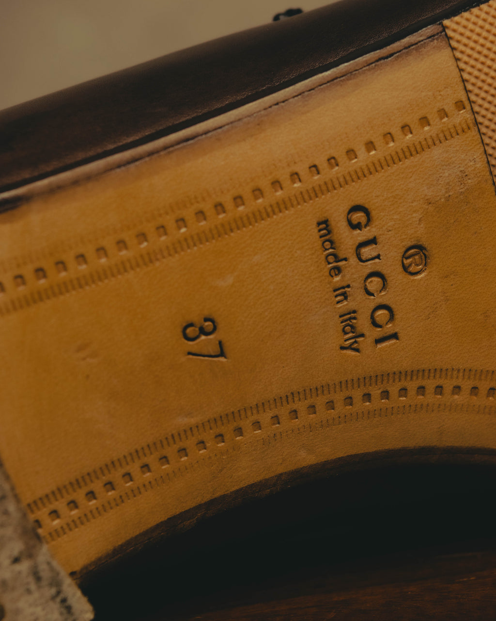 インソールに配されたGUCCIの刻印と「made in Italy」表記、サイズ37を確認できるカット。履き口周りのステッチも写しています。