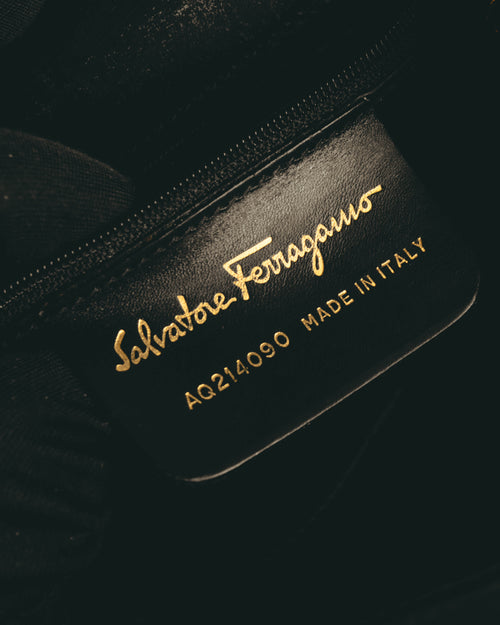 内装に配された革製パッチのアップ。Salvatore Ferragamoの筆記体ロゴ、品番「AQ214090」、MADE IN ITALYの金色表記が確認できます。
