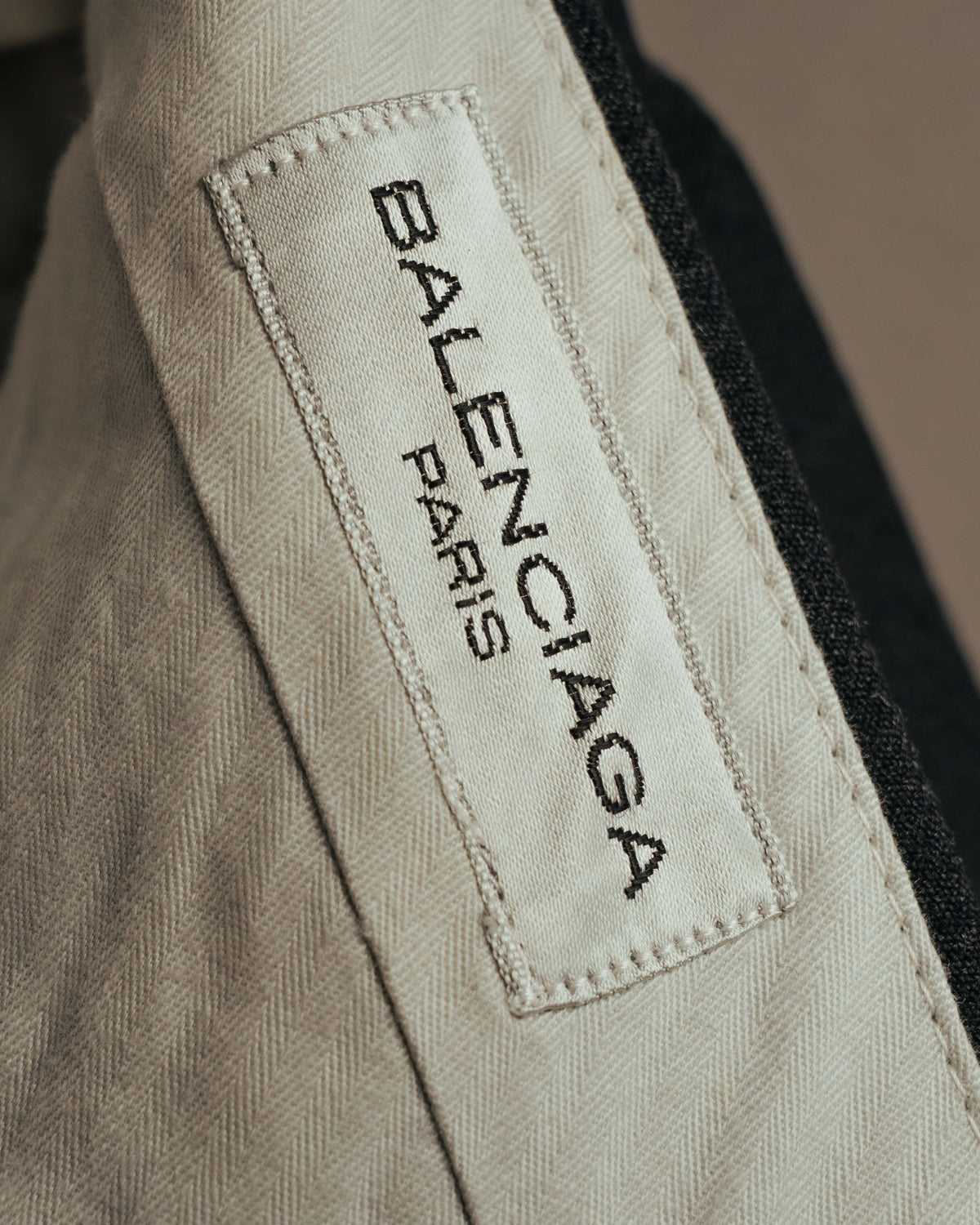 生成り色の腰裏に縫い付けられた「BALENCIAGA PARIS」表記のブランドタグ。ウエスト内側の丁寧な内部仕様を確認できるカット。