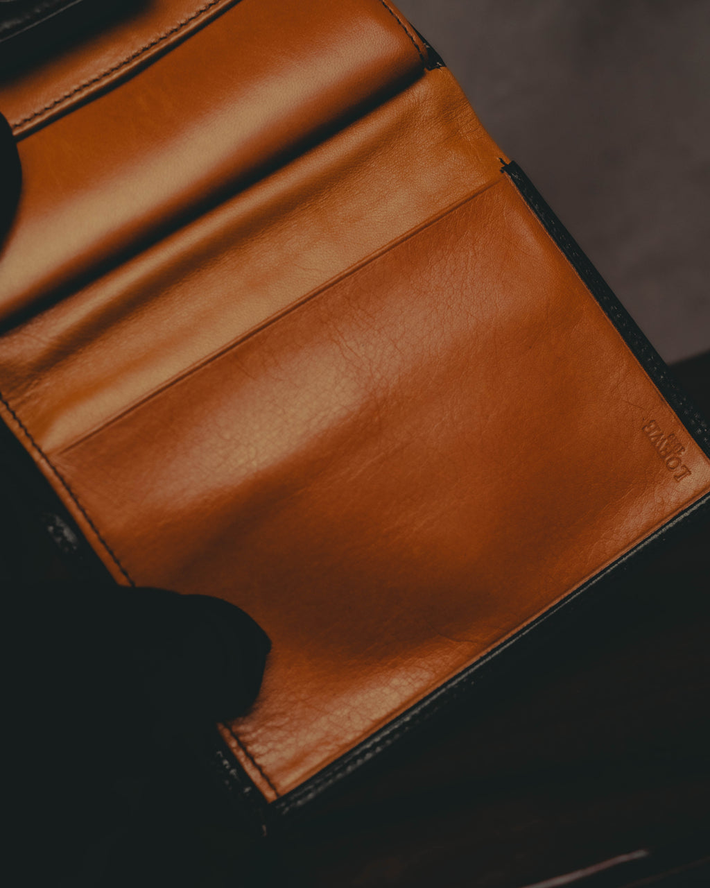 明るいキャメルカラーの内装レザーを捉えたディテールカット。収納部の縁にLOEWE 1846の型押し表記が確認できます。