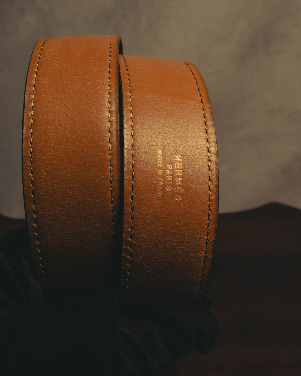 明るいキャメルブラウンの裏面レザーに配された「HERMÈS PARIS MADE IN FRANCE」の刻印を捉えたカット。両端に施されたステッチと、表裏で異なるレザーの色合いも確認できます。