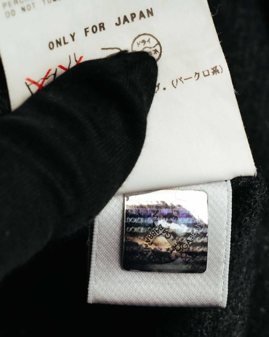 「ONLY FOR JAPAN」表記を含む品質表示タグと、DOLCE & GABBANA表記のセキュリティーホログラムを写した内側のタグカット。