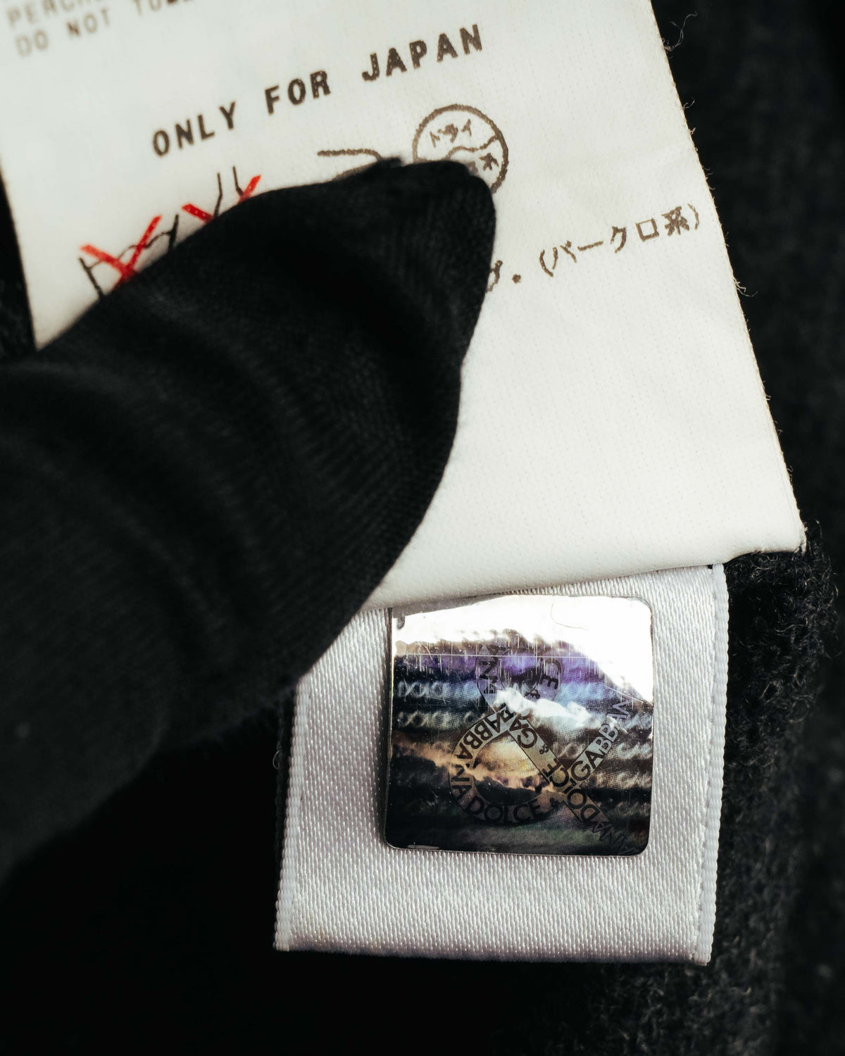「ONLY FOR JAPAN」表記を含む品質表示タグと、DOLCE & GABBANA表記のセキュリティーホログラムを写した内側のタグカット。