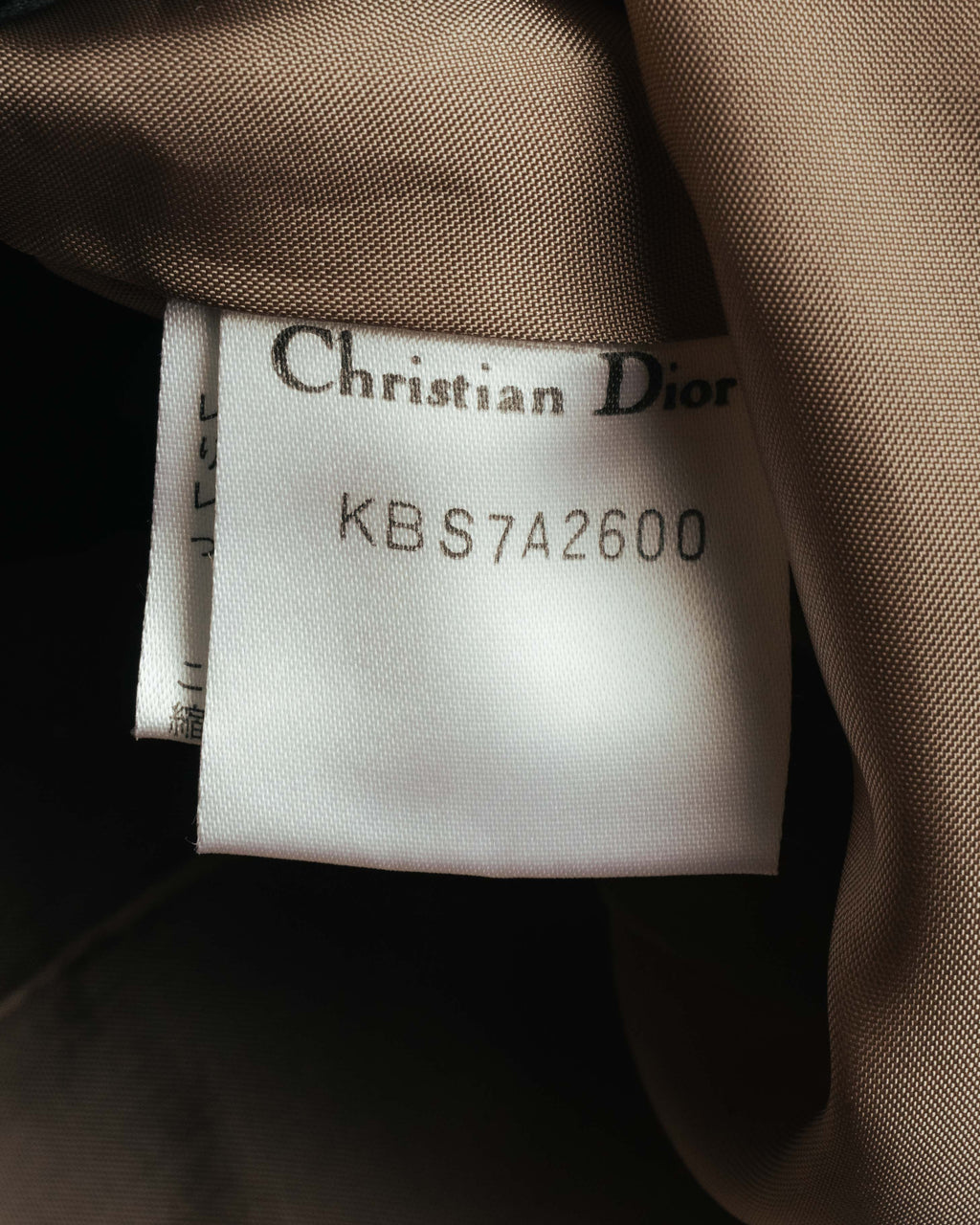 襟元に配されたChristian Diorの織りタグと、品番「KBS7A2600」を確認できる内側のカット。総裏仕立ての裏地もあわせて写しています。