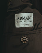「ARMANI COLLEZIONI」とMADE IN ITALY表記が確認できる内タグのカット。落ち着いたブラウンの裏地と、全体の色彩に溶け込む同系色ボタンも写しています。