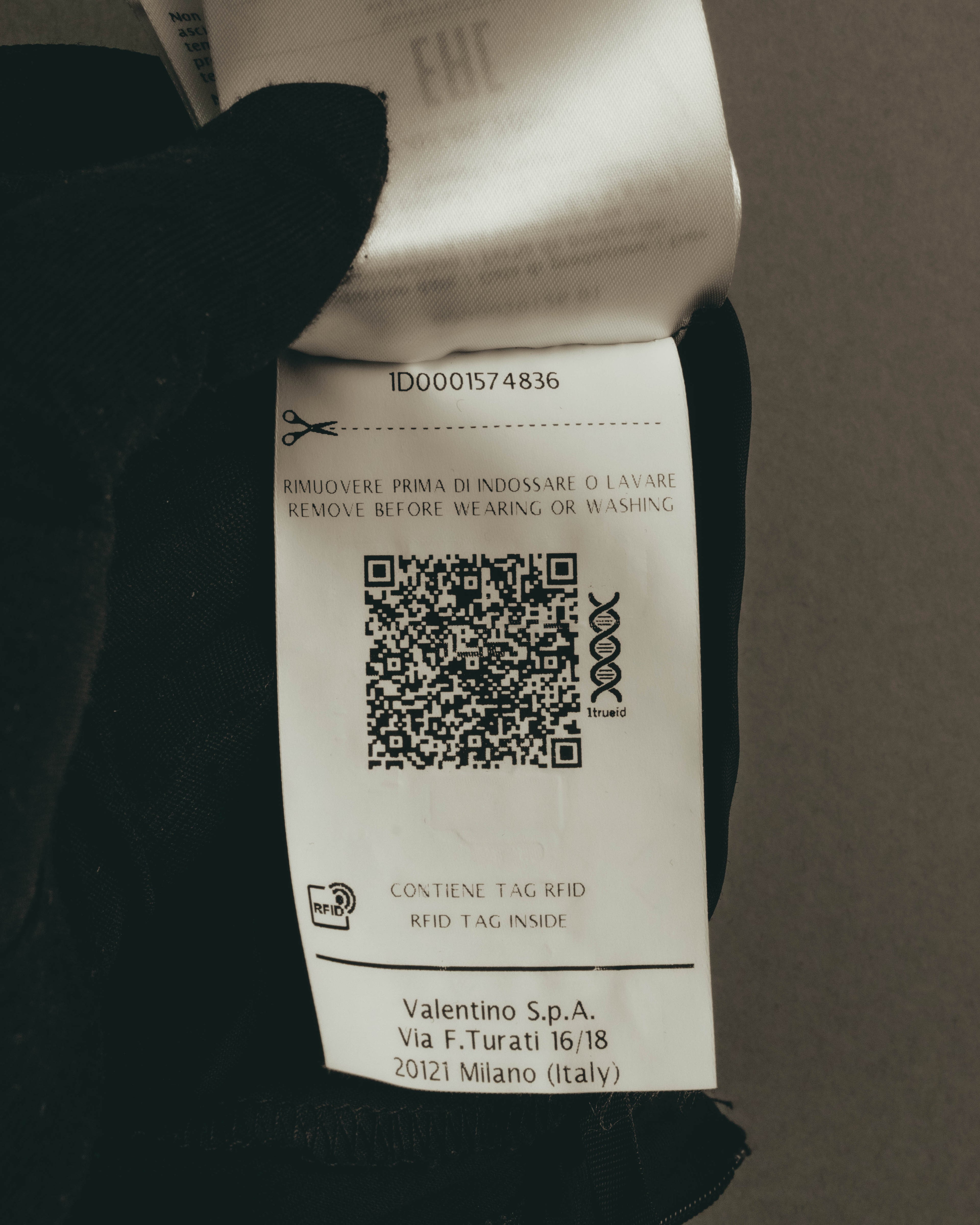 QRコードと「RFID TAG INSIDE」の表記を確認できる管理タグのカット。近年のブランドプロダクトとしての背景を伝える、QR管理タグおよびRFIDタグが残されたディテールです。