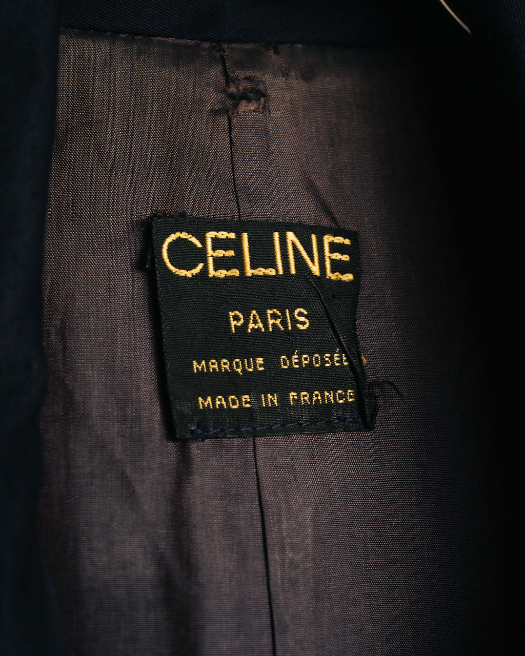 黒地に金文字で「CELINE PARIS」「MARQUE DÉPOSÉE」「MADE IN FRANCE」と織られた、首元の旧タグを捉えたカット。