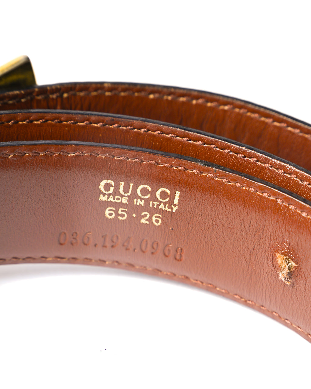 ベルト内側に配された「GUCCI MADE IN ITALY」、サイズ「65・26」、型番「036.194.0908」の刻印を捉えたカット。ブラウンレザーの内側と縁部分のステッチワークも確認できます。