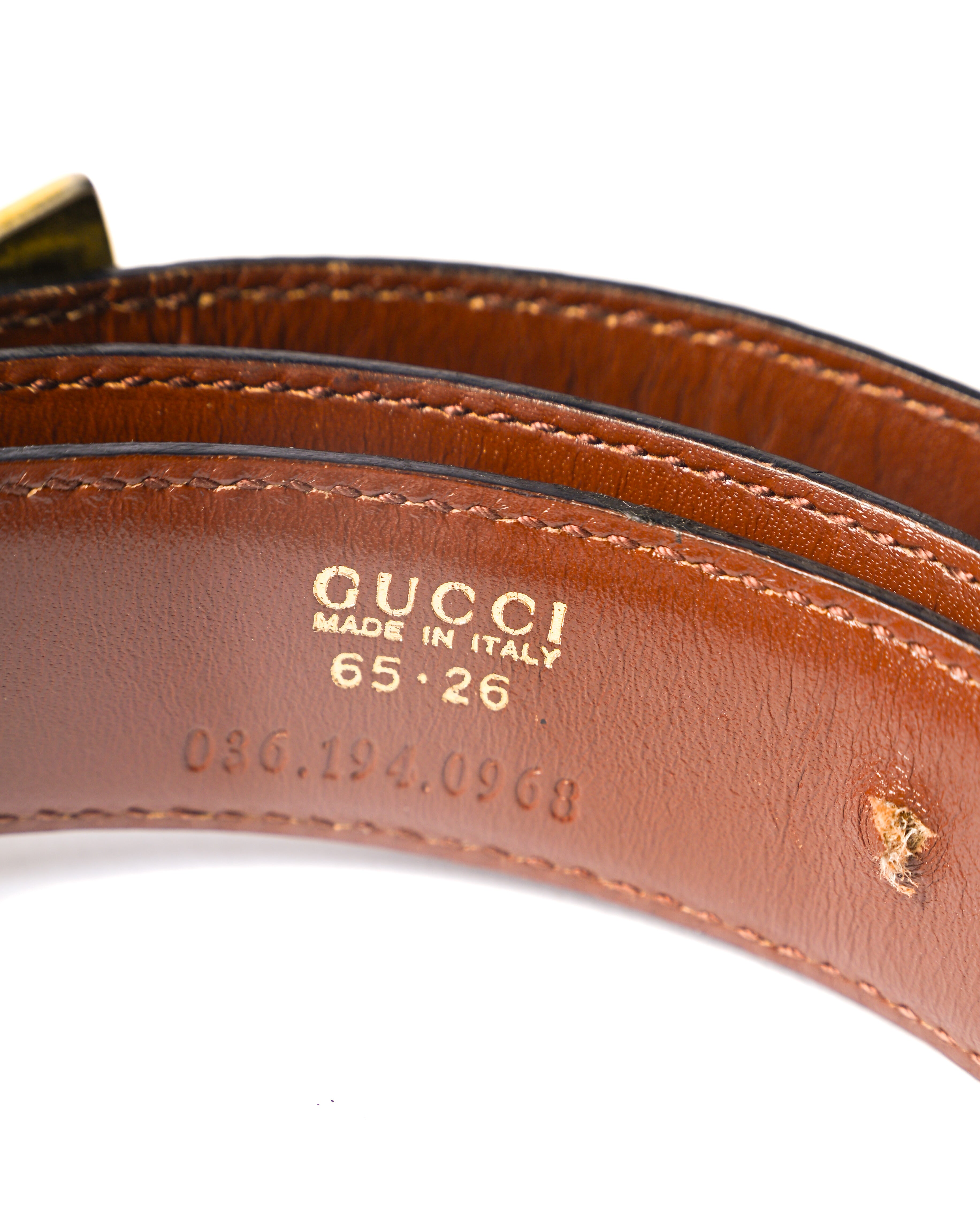 ベルト内側に配された「GUCCI MADE IN ITALY」、サイズ「65・26」、型番「036.194.0908」の刻印を捉えたカット。ブラウンレザーの内側と縁部分のステッチワークも確認できます。