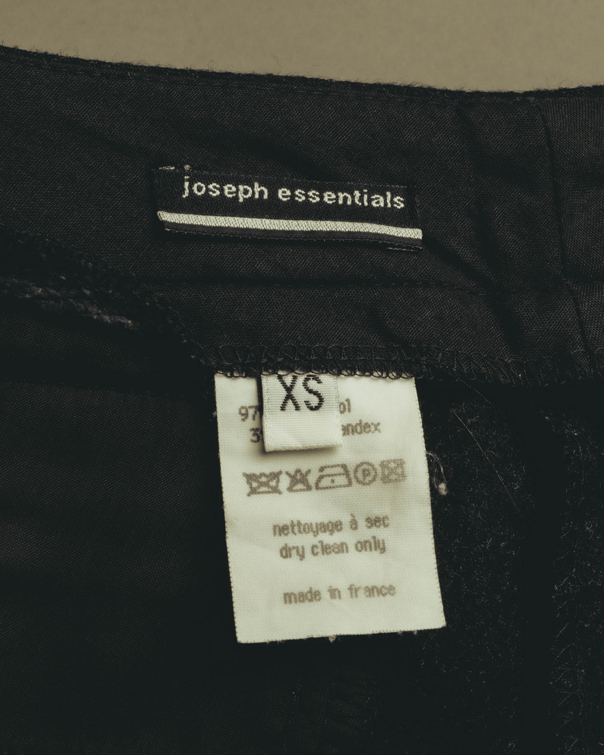 黒地に白い小文字ロゴと横線を配したjoseph essentialsの織りネーム、XS表記のサイズタグ、品質表示タグを写した内側のタグカット。品質表示にはウール97％・ライクラ3％の混率、フランス製表記、フランス語・英語のケア表記が確認できます。