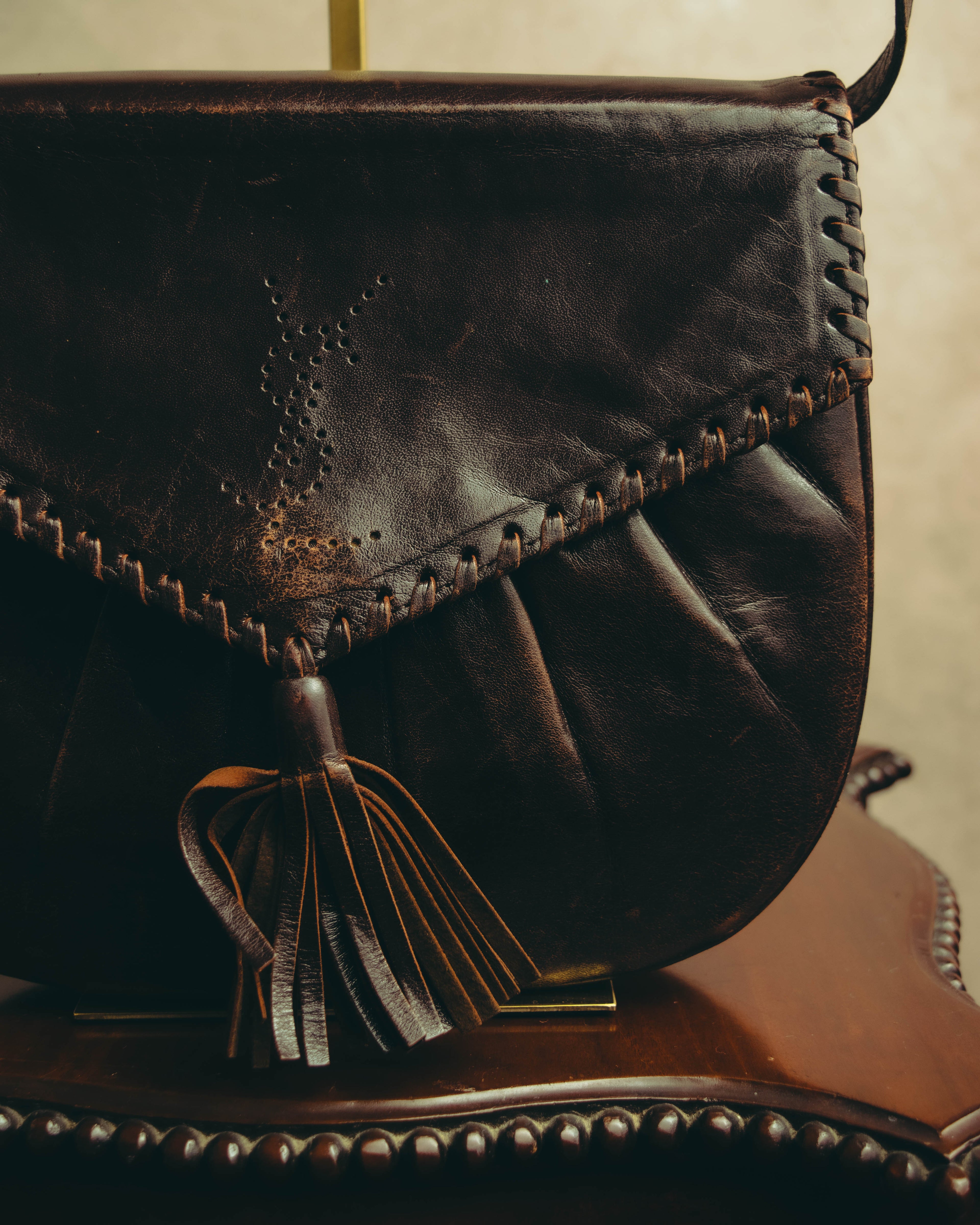 “Yves Saint Laurent” 70’s-80’s Perforated logo leather tassel shoulder bag