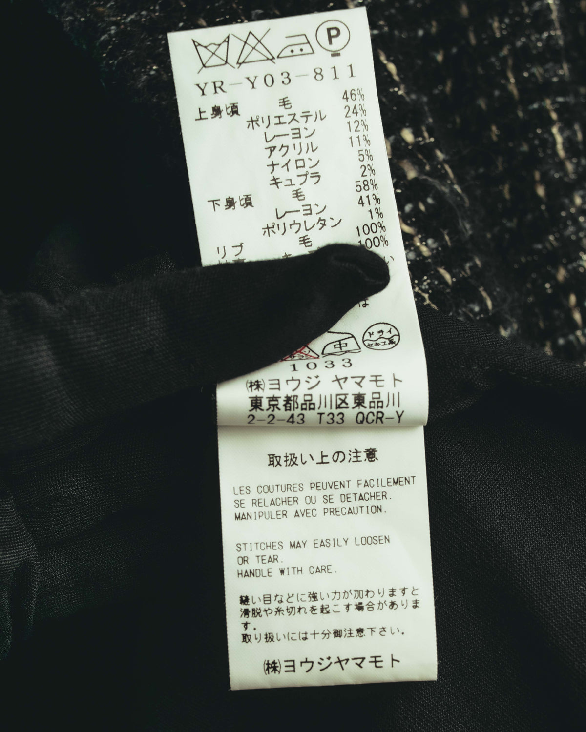 品番YR-Y03-811と、上身頃・下身頃・リブそれぞれの素材構成が確認できる品質表示タグ。ヨウジヤマモト表記および取扱い表示も写る内タグのカット。