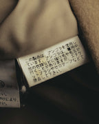 アンゴラ使用に関する注意書きが読める、日本語の品質表示タグのクローズアップ。滑らかなキュプラ裏地とあわせて確認できるカットです。