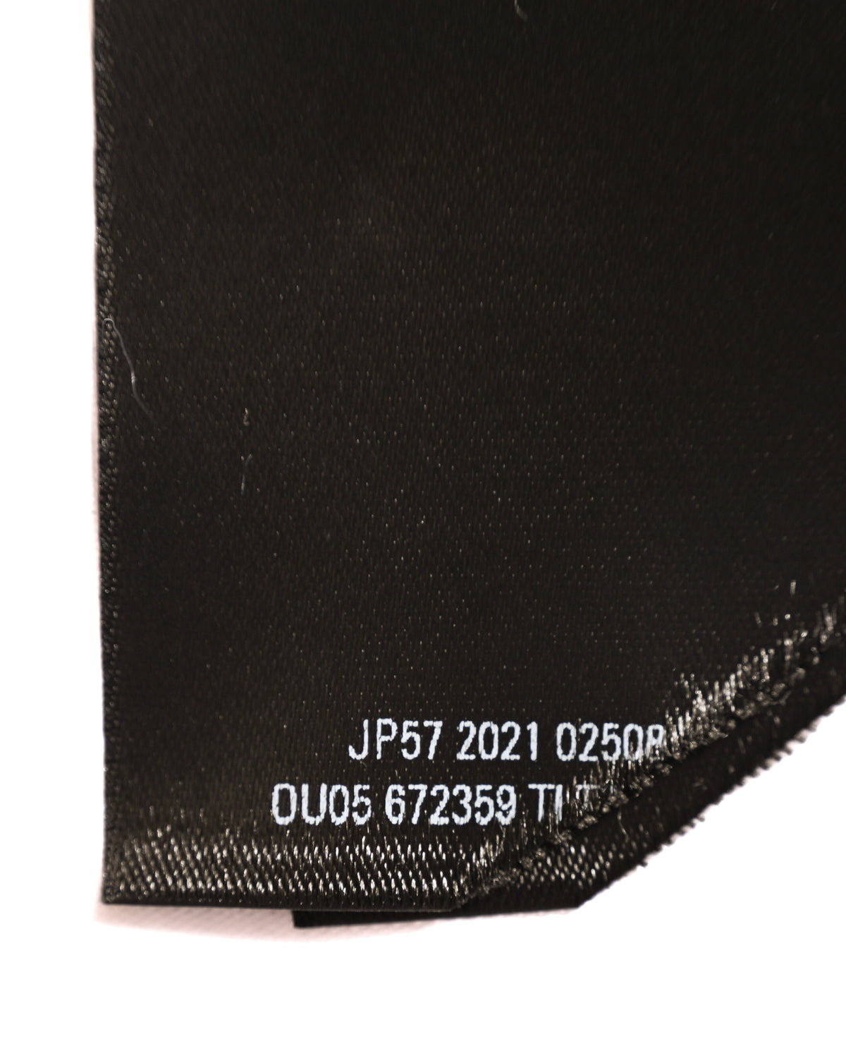 ウエスト内側に配されたブラックの内タグ下部。白字で「JP57 2021 02500」「OU05 672359」などの品番・製造情報が確認できるカット。