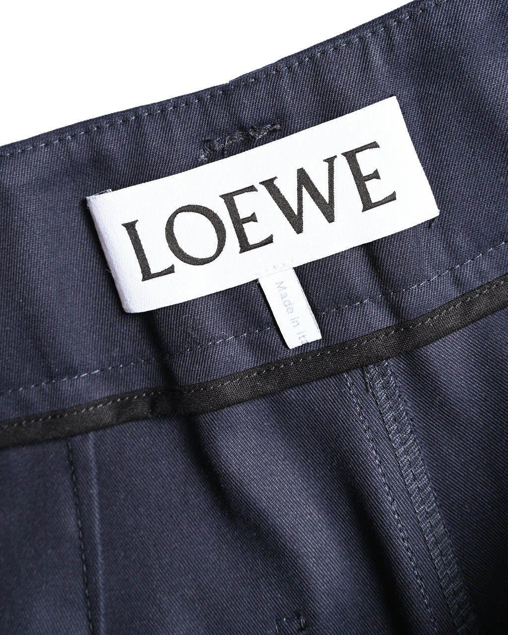 ダークネイビーのウエスト内側に配されたLOEWEのブランドタグを捉えたカット。周囲には同色のパイピングと縫製が確認できます。
