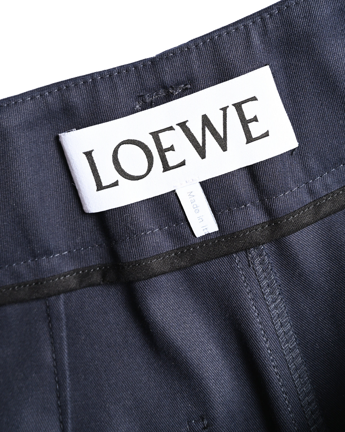 ダークネイビーのウエスト内側に配されたLOEWEのブランドタグを捉えたカット。周囲には同色のパイピングと縫製が確認できます。