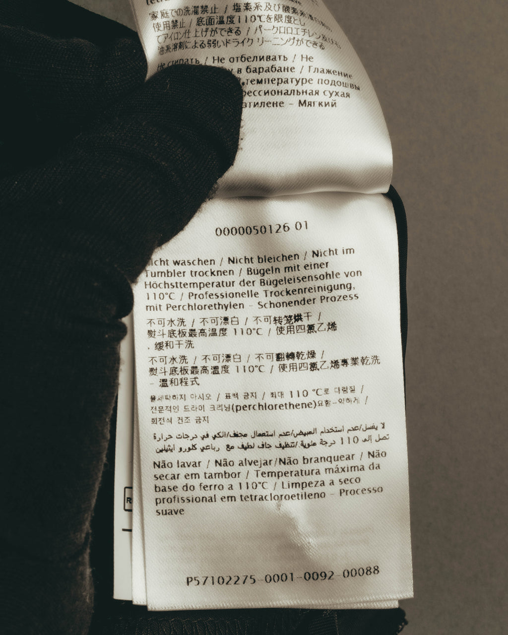 多言語で洗濯表示と品番表記が確認できる、パンツ内側の品質表示タグのカット。