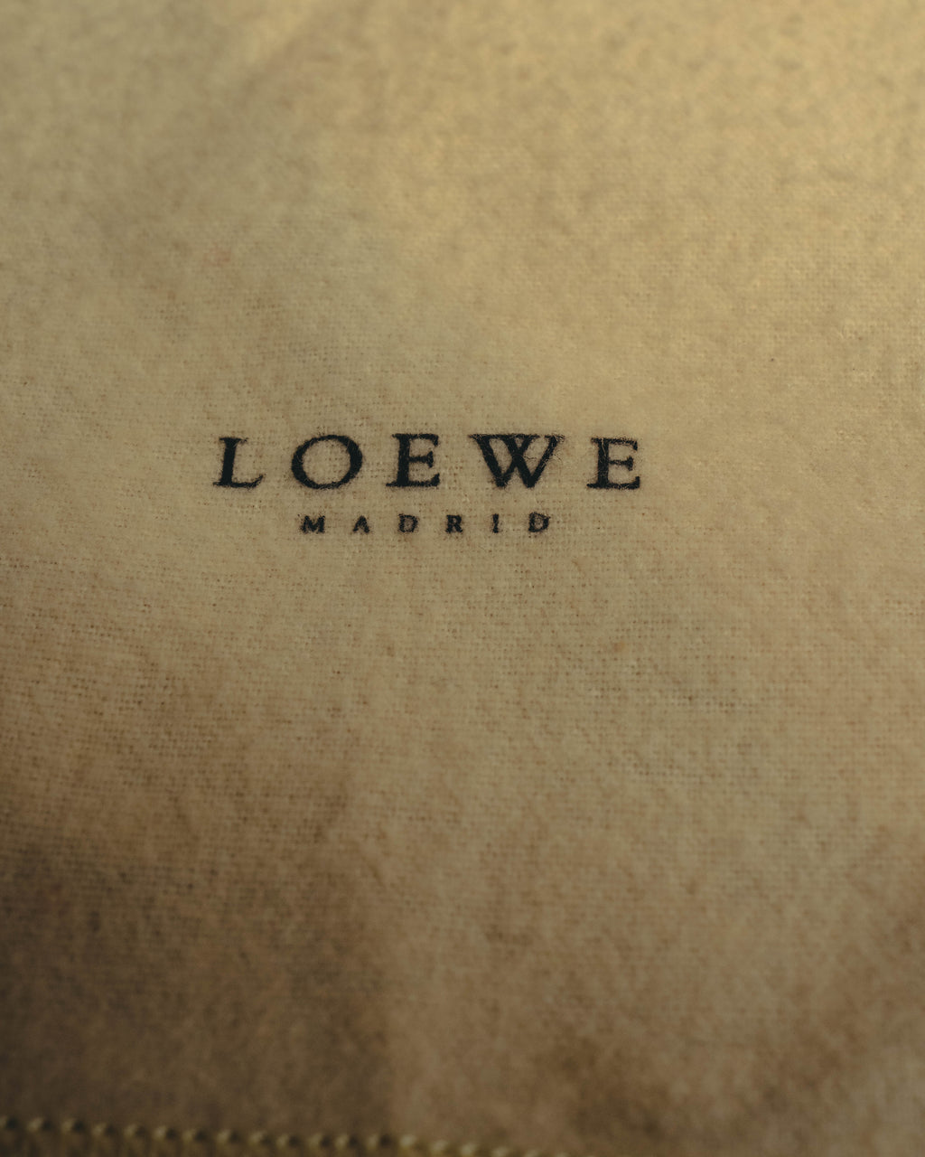 生成りに近い付属布に入る、LOEWE MADRIDのプリントを捉えたディテールカット。布地表面の細かな織りと、下端の縫製も確認できます。