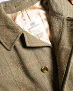 王室御用達を示す表記、Aquascutum OF LONDON、MADE IN ENGLANDの文字を織り込んだ旧仕様のブランドタグを捉えた内側のカット。滑らかな総裏地と、細い格子柄を重ねたヘリンボーン生地、ステンカラーも確認できます。