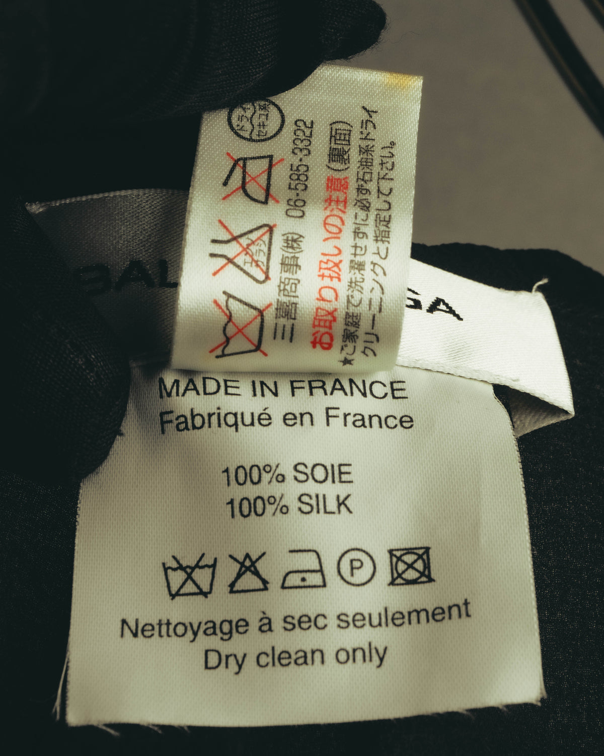 品質表示タグに「100% SOIE / 100% SILK」と「MADE IN FRANCE / Fabriqué en France」の表記が確認できるカット。日本語付加タグには大阪06地域の電話番号表記も見られます。