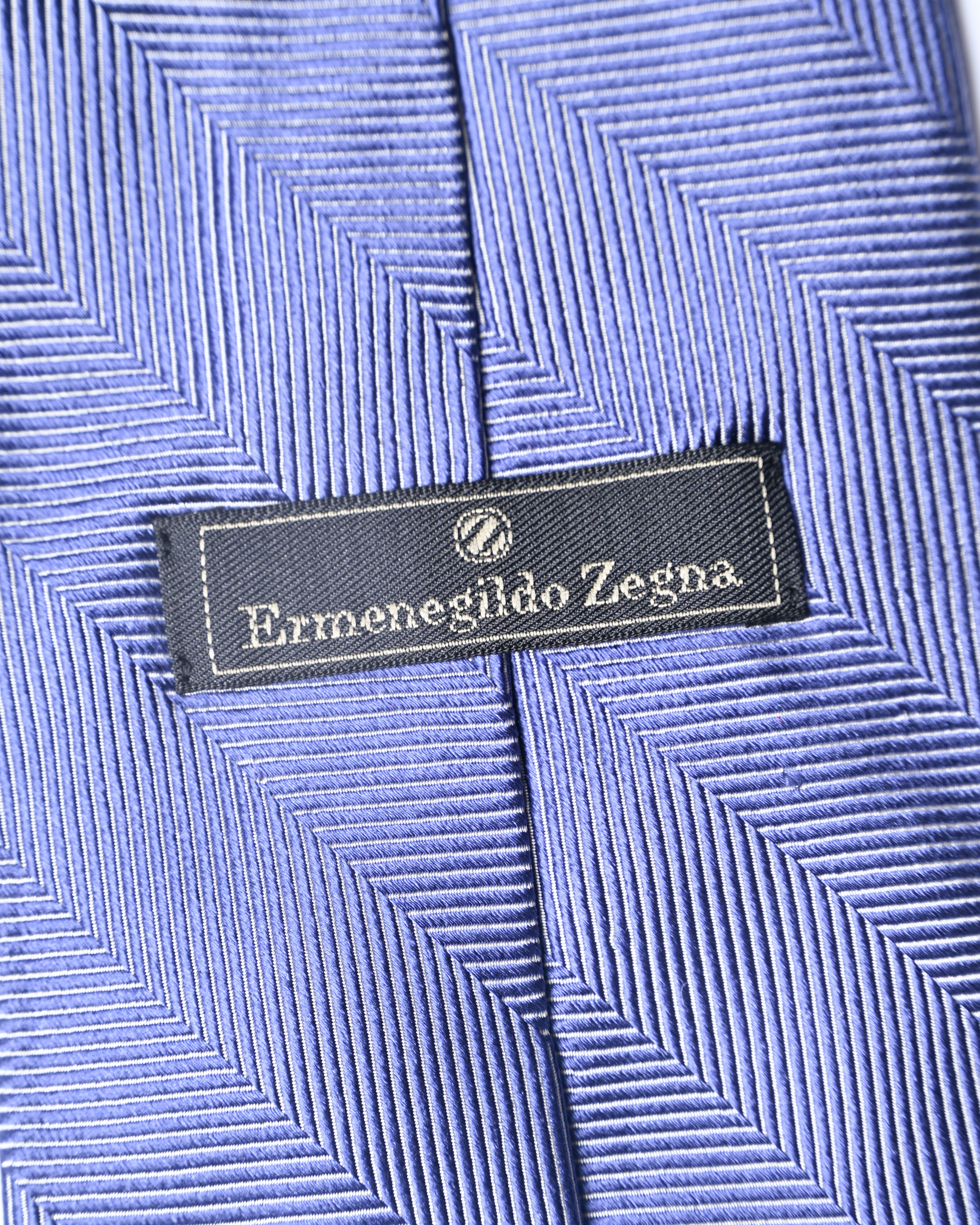小剣通しの裏側に配されたErmenegildo Zegnaのブランドネーム刺繍入り裏地。ブルーの生地には、立体的な陰影を生む斜めストライプのジャカード織りが確認できます。