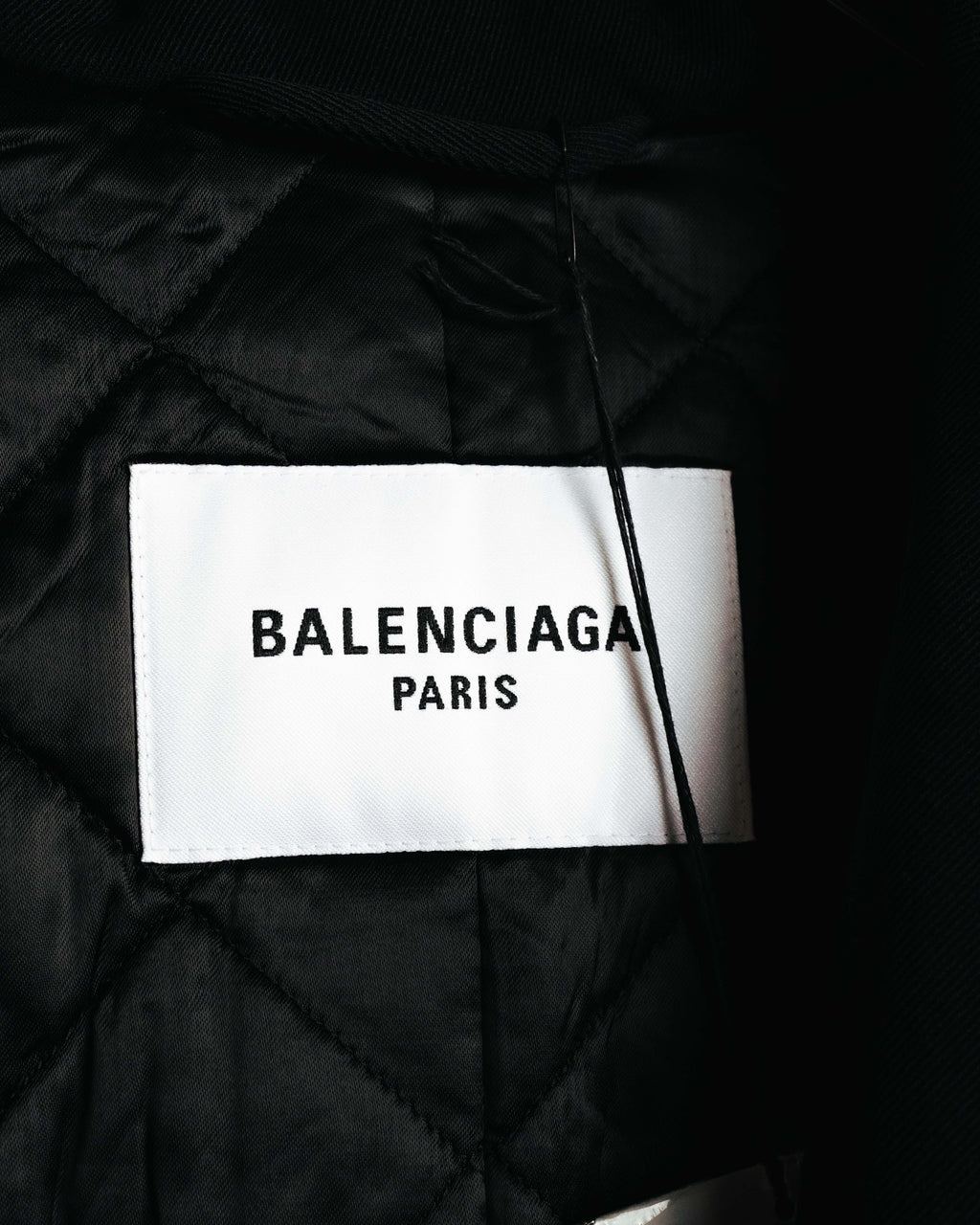 白地に黒文字でBALENCIAGA PARISと記された襟元の内タグ。周囲には厚みのあるキルティング仕立てのブラック裏地が確認できます。
