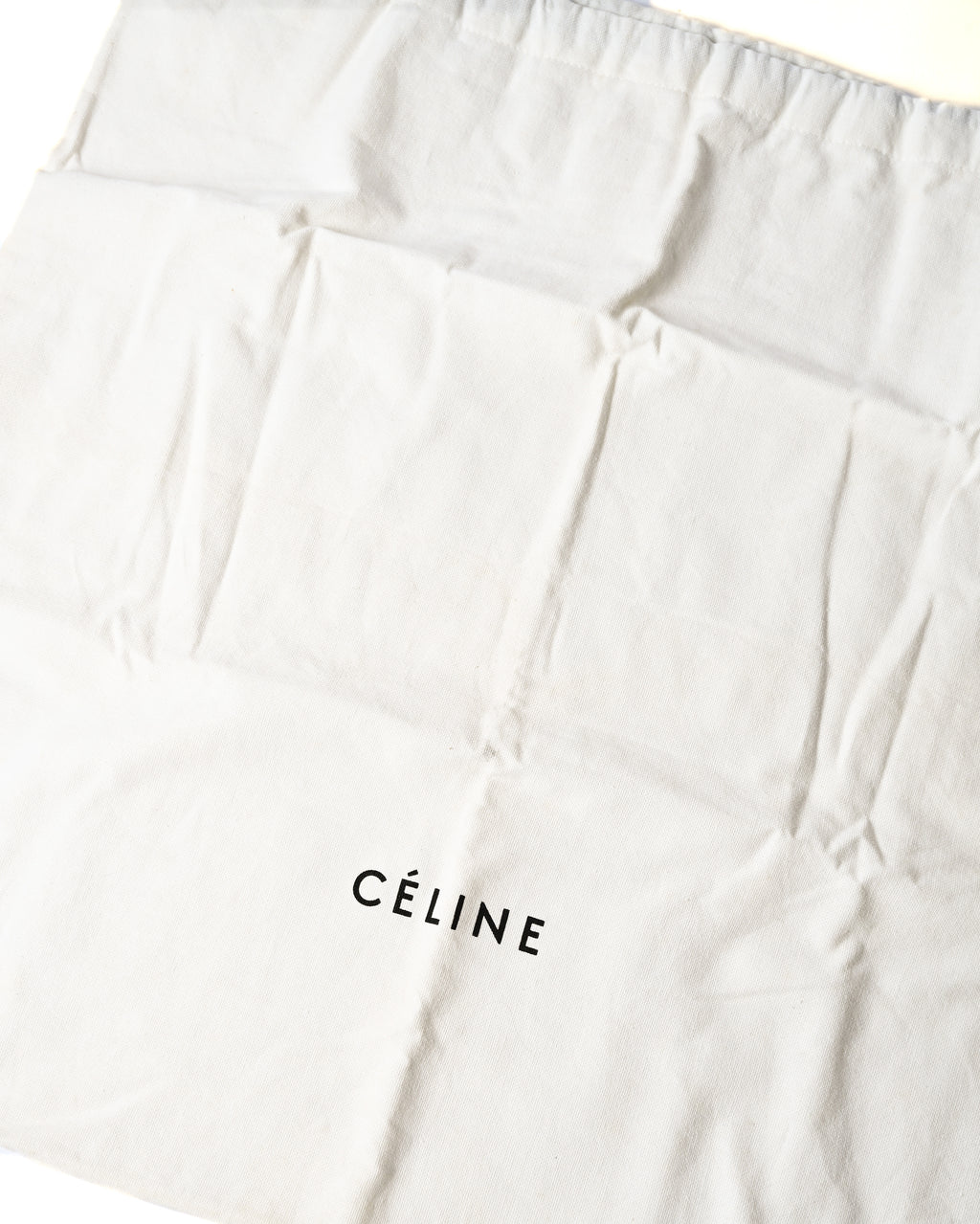 「CÉLINE」ロゴがプリントされた白い保存袋のカット。バッグ本体に付属する保管用の布袋を確認できます。