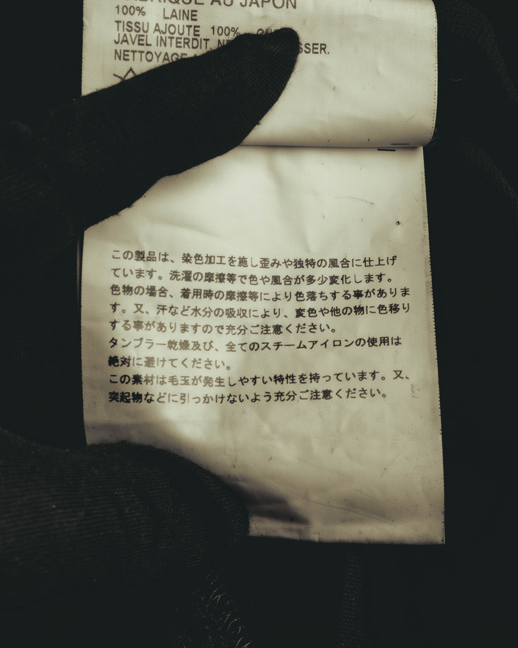 本体ウール100%の表記と、染色加工・毛玉に関する注意書きが確認できる品質表示タグのカット。