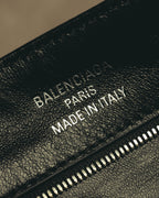 シボ感のあるブラックの内装に施された「BALENCIAGA PARIS MADE IN ITALY」の銀色箔押しと、ファスナーポケットを捉えたディテールカット。