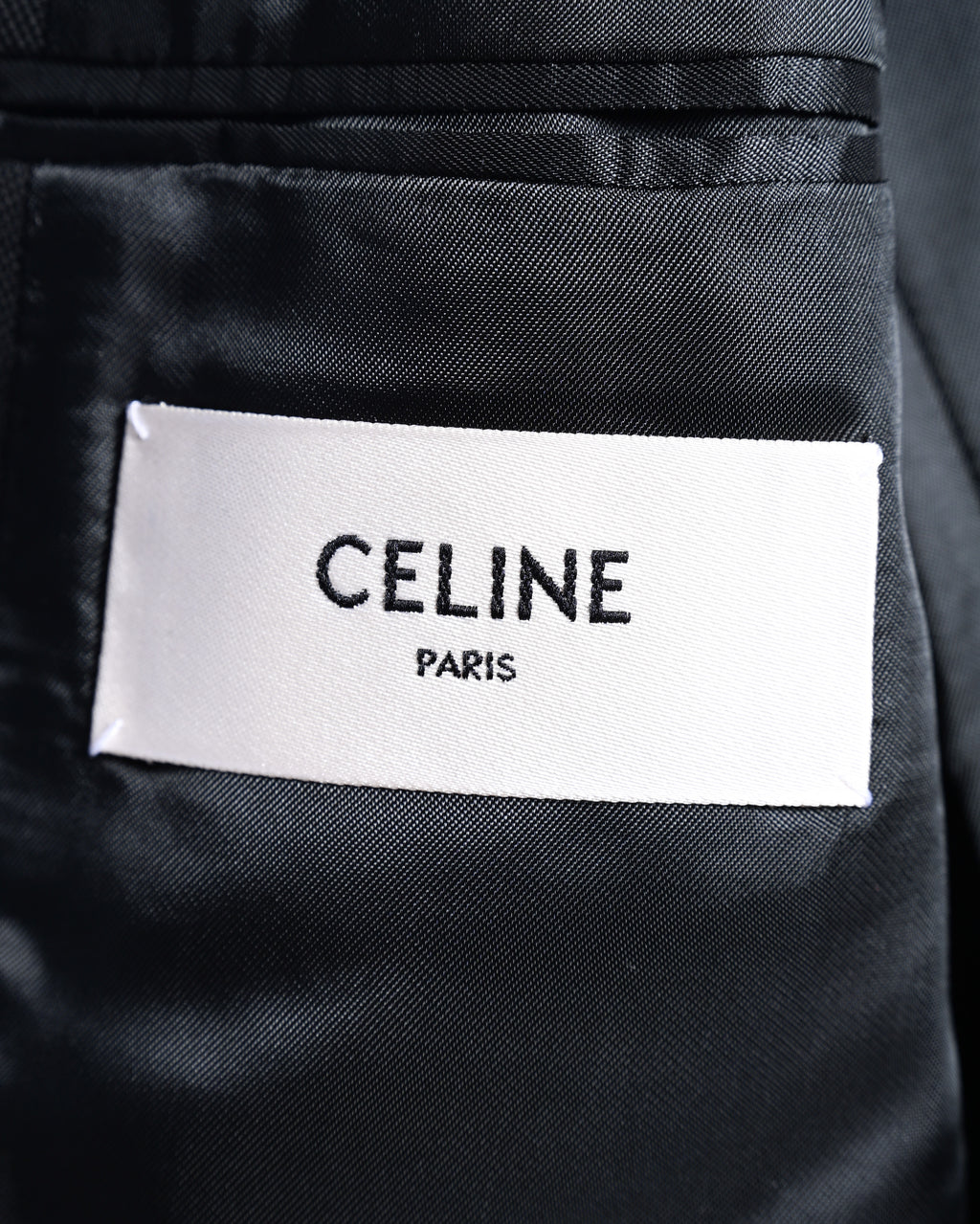 ジャケット内側に配された「CELINE PARIS」表記のブランド内タグ。黒い裏地とのコントラストでタグ表記を確認できるカット。