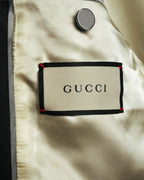 黄みを含んだアイボリーからシャンパンを思わせる総裏地に配されたGUCCIのブランドタグ。上部には内ポケットのボタンが写る内側のディテールカット。