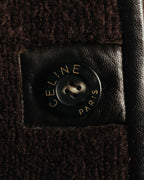 CELINE PARISの表記が刻まれた4穴ボタンを、ダークブラウンのレザー台座とともに捉えたディテールカット。起毛感のある本体生地とレザートリミングの異素材使いが確認できます。