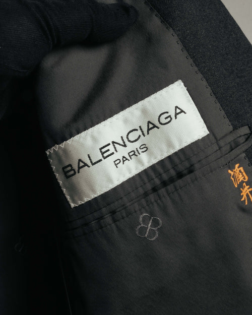 内側に配された白地に黒字のBALENCIAGA PARISタグと、内ポケット付近に残る橙色のネーム刺繍を捉えたカット。ダークトーンの裏地にはBBモノグラムも確認できます。