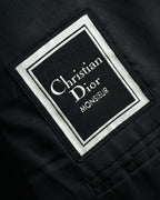 黒地に白い織り文字と二重枠を配した、Christian Dior Monsieurのブランドタグ。滑らかな裏地に縫い付けられた内側のタグを確認できるカット。
