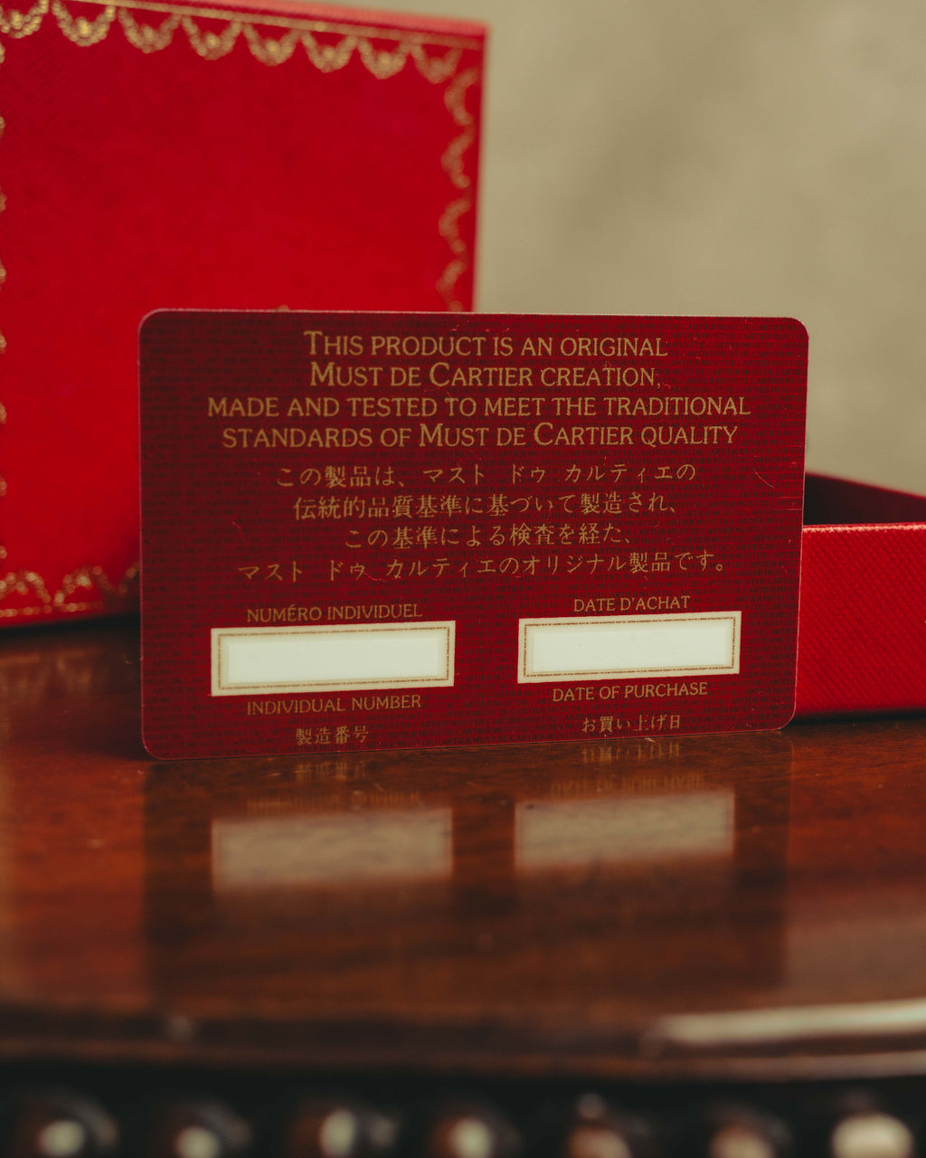Must de Cartierの赤い保証カードを写したカット。個別番号と購入日を記入する欄、オリジナル製品である旨の表記が確認できます。