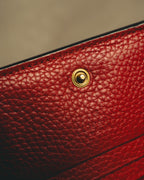 深みのあるレッドのグレインレザーに配されたスナップボタンと、内側に確認できるGUCCI made in italyの刻印を捉えたディテールカット。細かなシボとブラックのコバも確認できます。