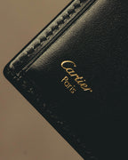 ブラックの内装に施されたCartier Parisのゴールド箔押しと、縁に並ぶカードスロットを捉えたディテールカット。