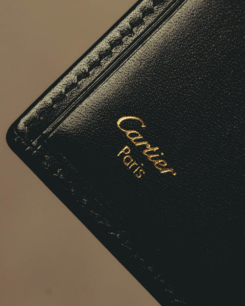ブラックの内装に施されたCartier Parisのゴールド箔押しと、縁に並ぶカードスロットを捉えたディテールカット。