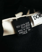 「100% SETA SILK」とイタリア製を示す表記が確認できる、黒地の素材・原産国表示タグのクローズアップ。隣にブランドネームタグの一部も写っています。