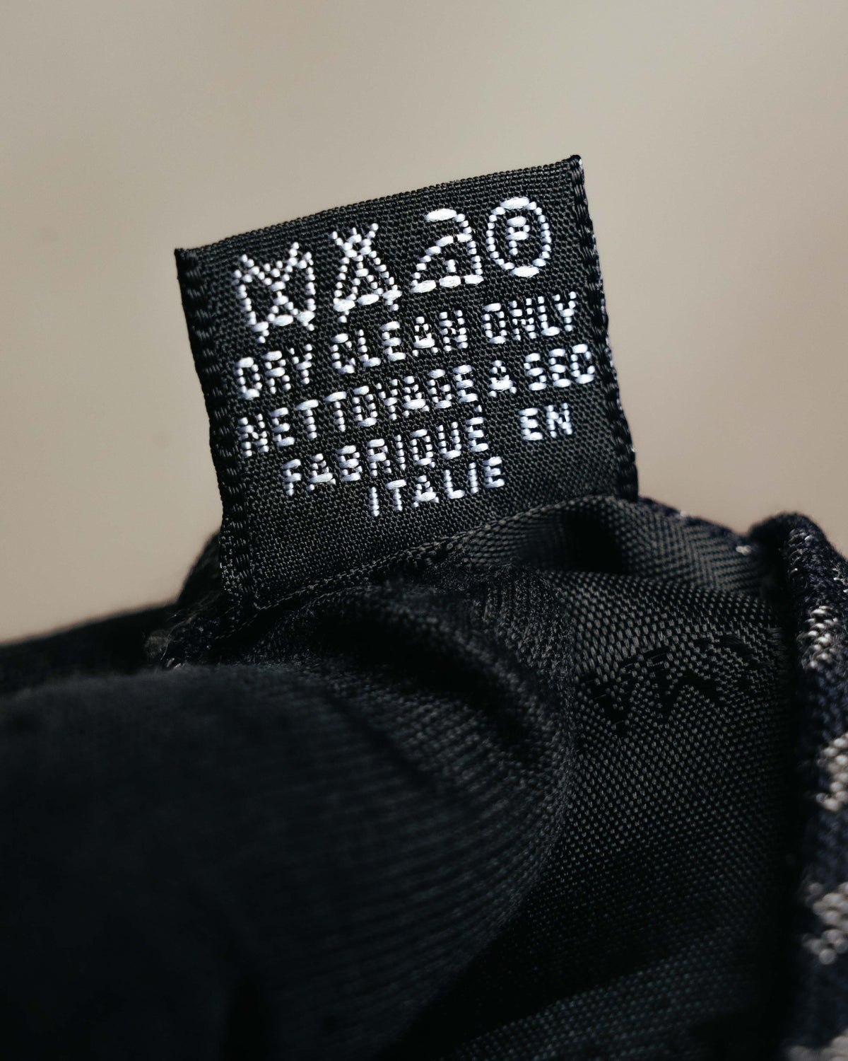 シルク85％・ビスコース15％、イタリア製を示す黒地の品質タグ。