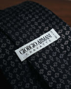 白地の織りネームに「GIORGIO ARMANI」「CRAVATTE」「MADE IN ITALY」の表記を配した内側のタグカット。周囲にはブランドネームを織り込んだジャカード裏地が見える。