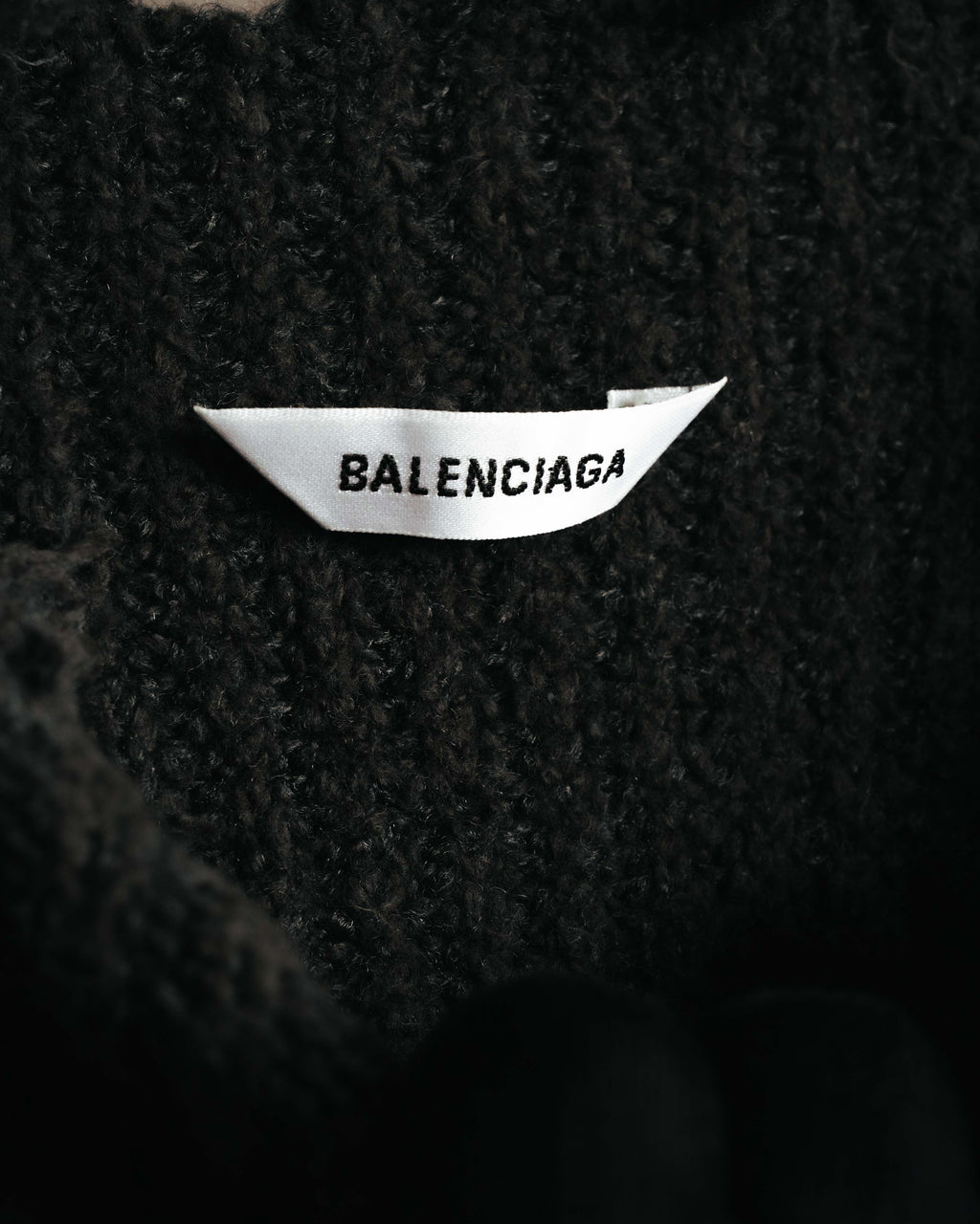 黒い畦編みの内側に配されたネックタグ。BALENCIAGAの表記を確認できるカットです。